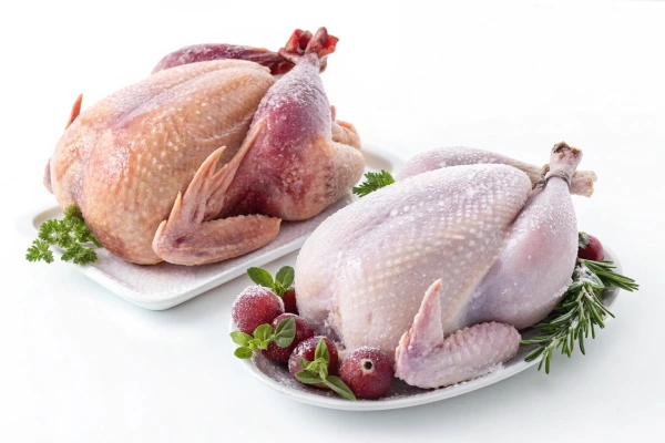 Comparison of fresh turkey on a butcher’s board and frozen turkey in packaging