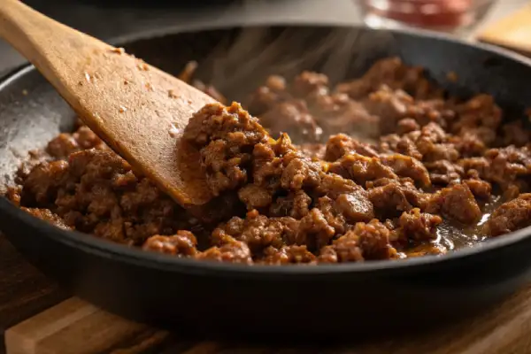 Close-up of ground beef browning in a skillet for Cheesy Beef and Bowtie Pasta